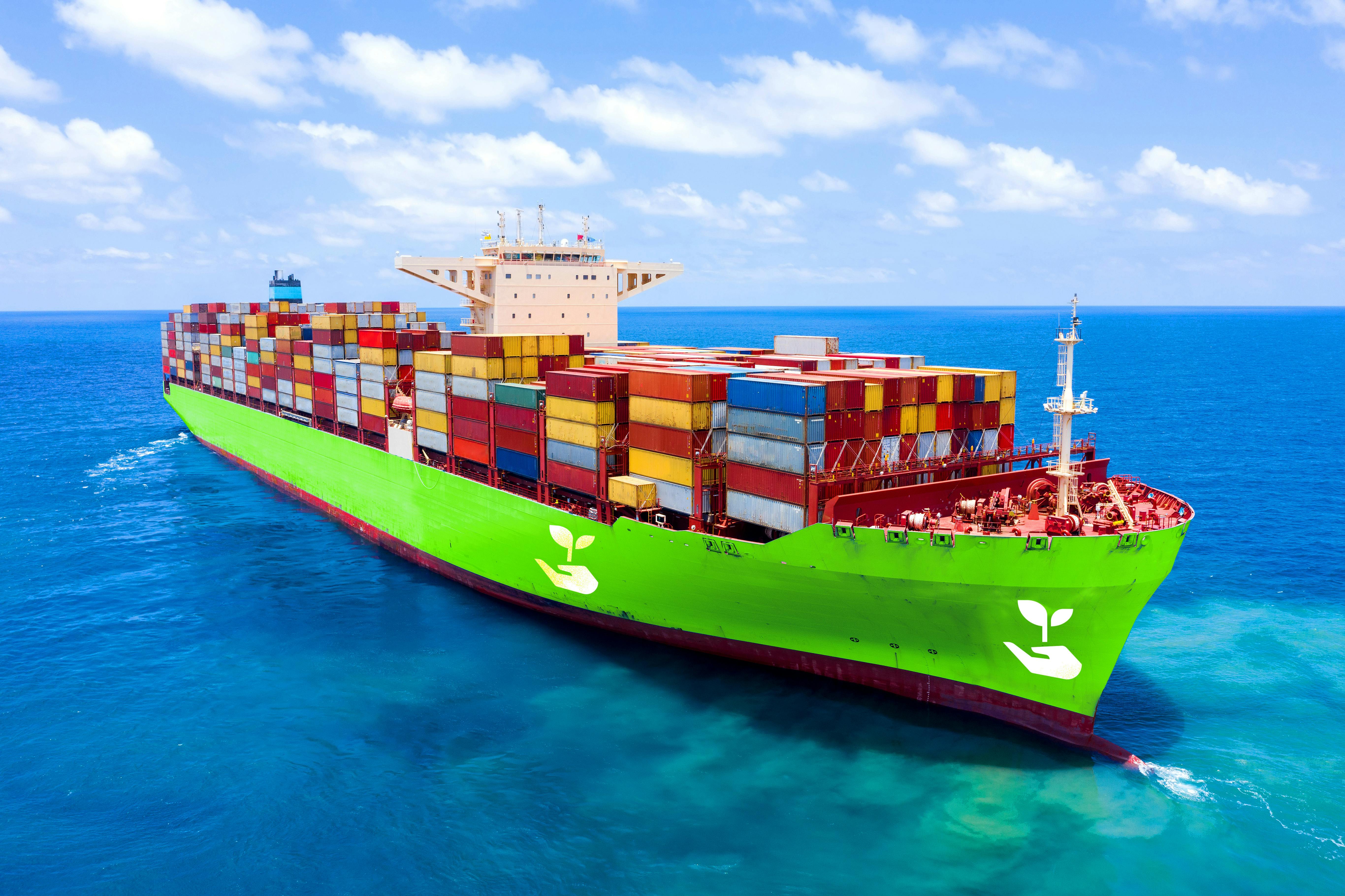 Green cargo ship sailing on the ocean.