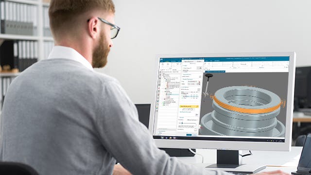 Mann programmiert Software an einem Computer.