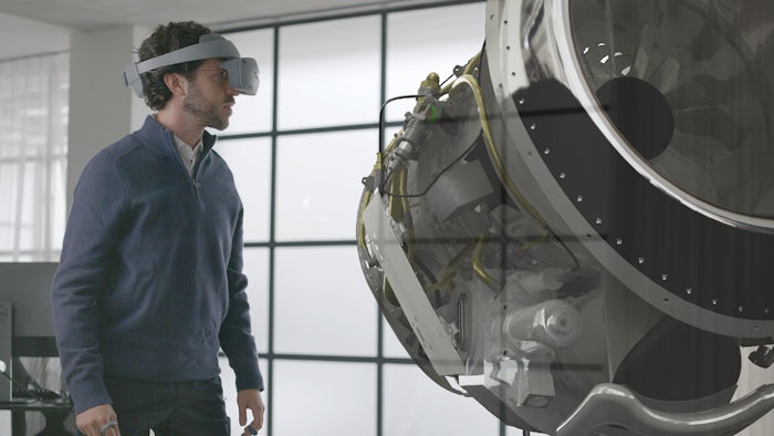 Man using Sony VR headset and Siemens NX Immersive Designer software to work on a jet engine.