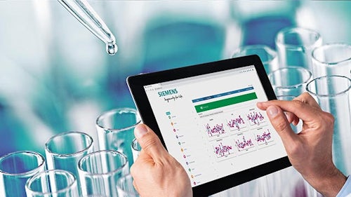 A tablet in hands with laboratory equipment in the background