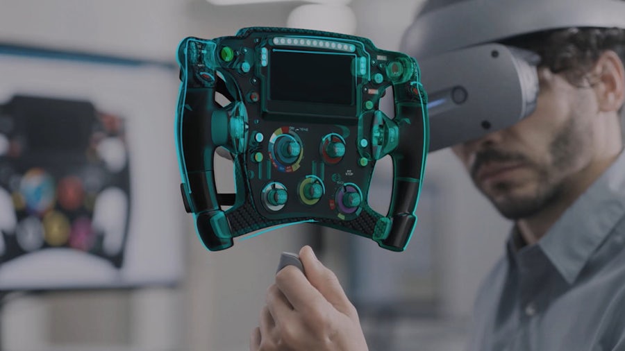 A man in virtual reality goggles looking at a virtually designed device in the foreground.