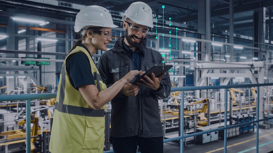 Woman on a tablet looking at data in a manufacturing plant