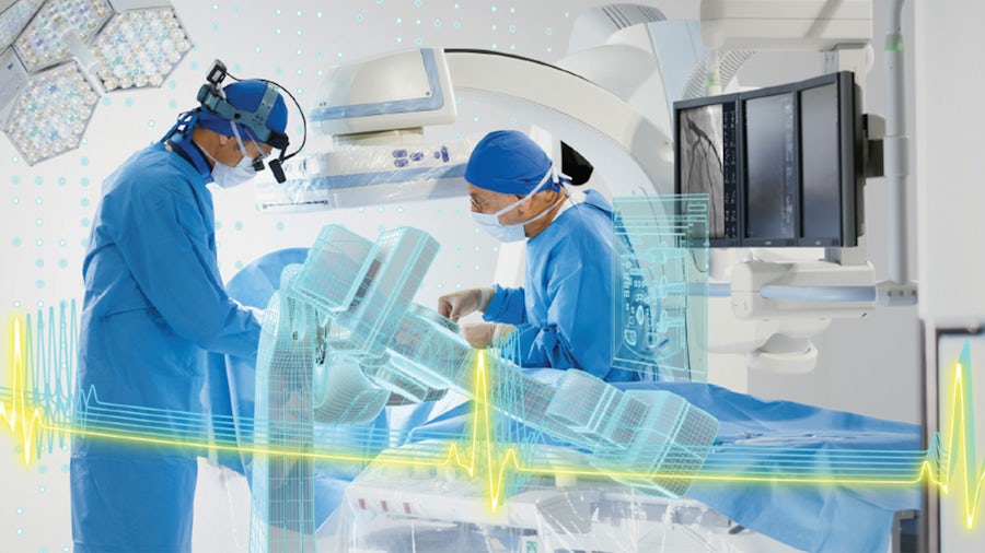 Two doctors in an operating room using a smart medical device.