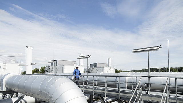 An engineer wearing PPE walking on top of the gas infrastructure building.