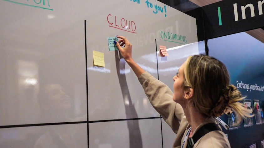 Participants engaging with each other using a whiteboard to share ideas at Realize LIVE 2022.