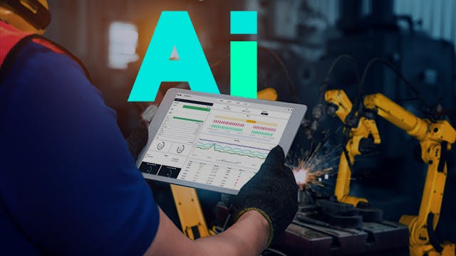 Male worker holding tablet in a production factory with robotic arms.