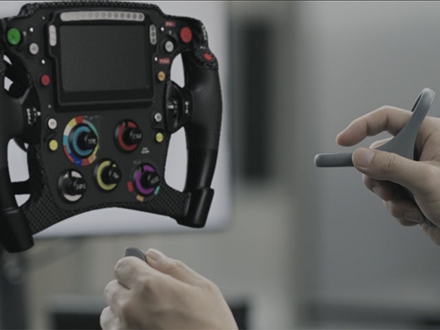 Person using the Sony VR head set and Siemens NX Immersive Designer software to work on a virtual model of a race car steering wheel.