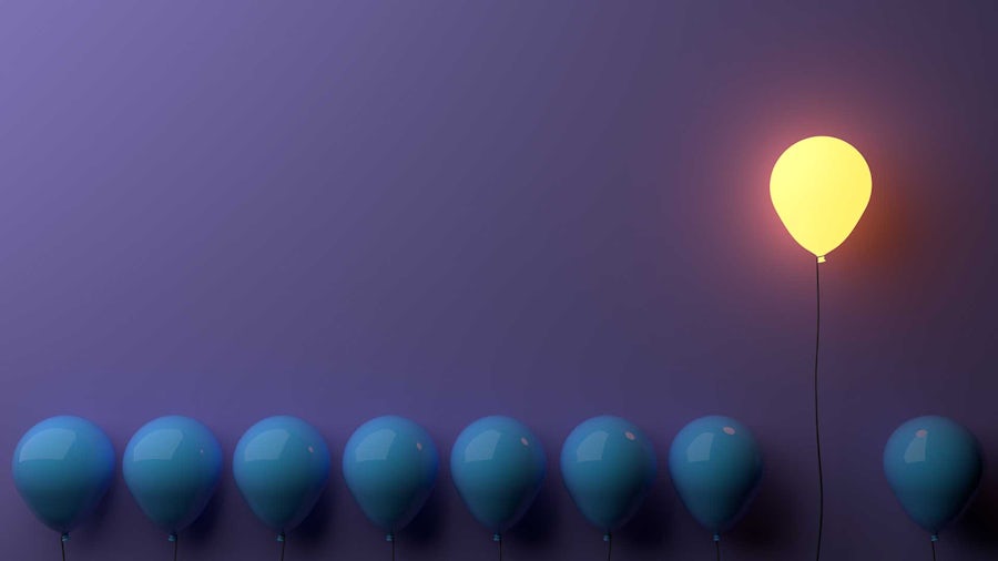 Purple background with a lit balloon rising above darker balloons.