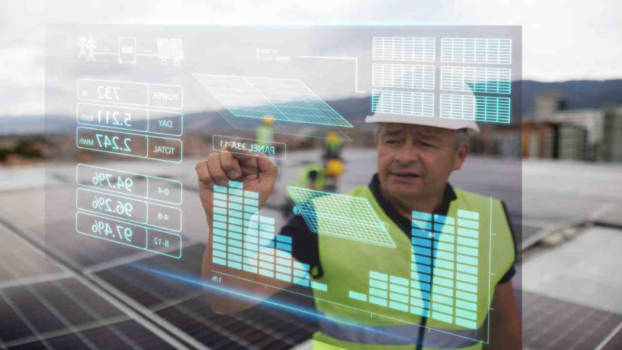 Ingegnere che utilizza un'interfaccia digitale per monitorare i dati dei pannelli solari.