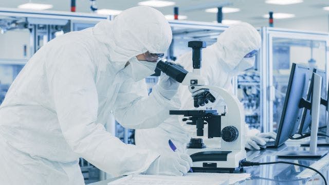 Person looking into a microscope.