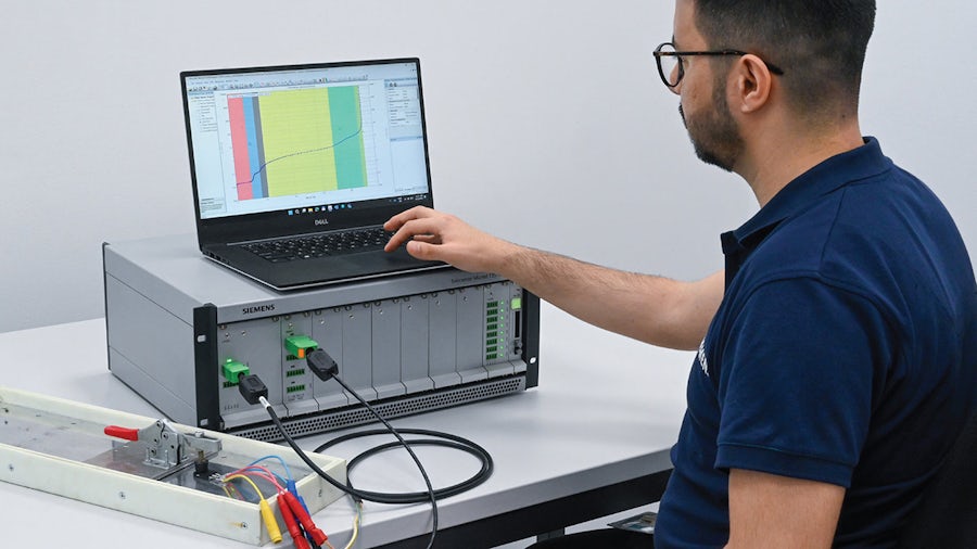 Simcenter Micred Testerのセットアップとテスト対象パワー・モジュールを使用する男性