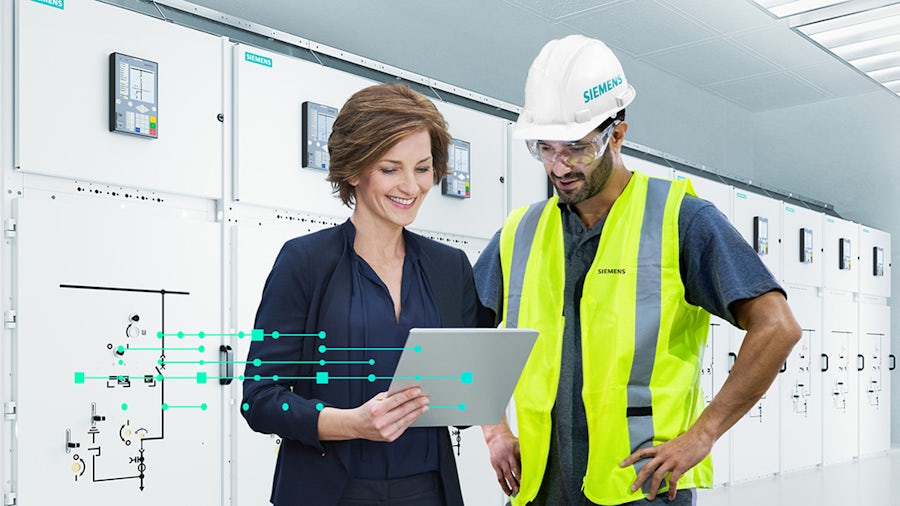 Executive with tablet and worker in yellow vest in front of a Siemens power bank