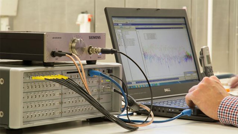 A person using a Simcenter amplifier device connected to a laptop.