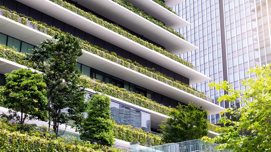 A modern, sustainable building with green spaces and solar panels, illustrating net-zero design.