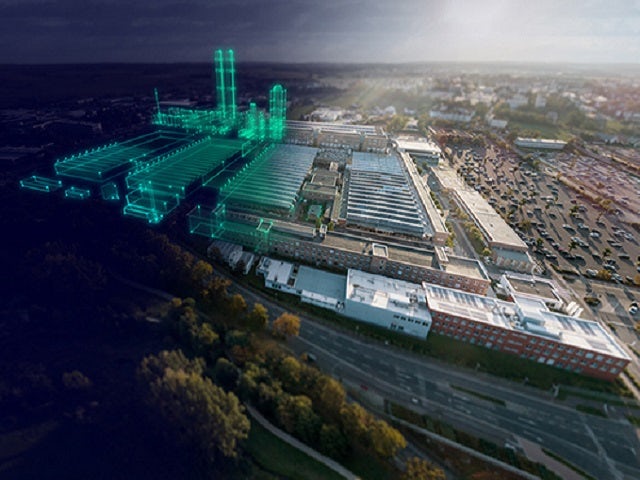 带有绿色数字叠加扩展的工厂的航拍照片。