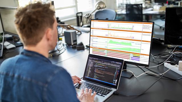 Engineer debugging software while graphing simulation results.