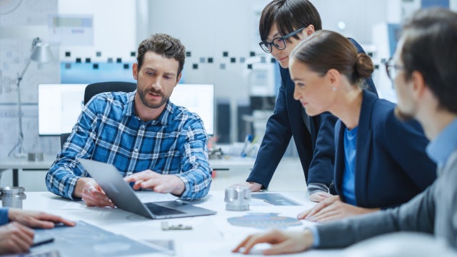 Engineers working together on a computer.