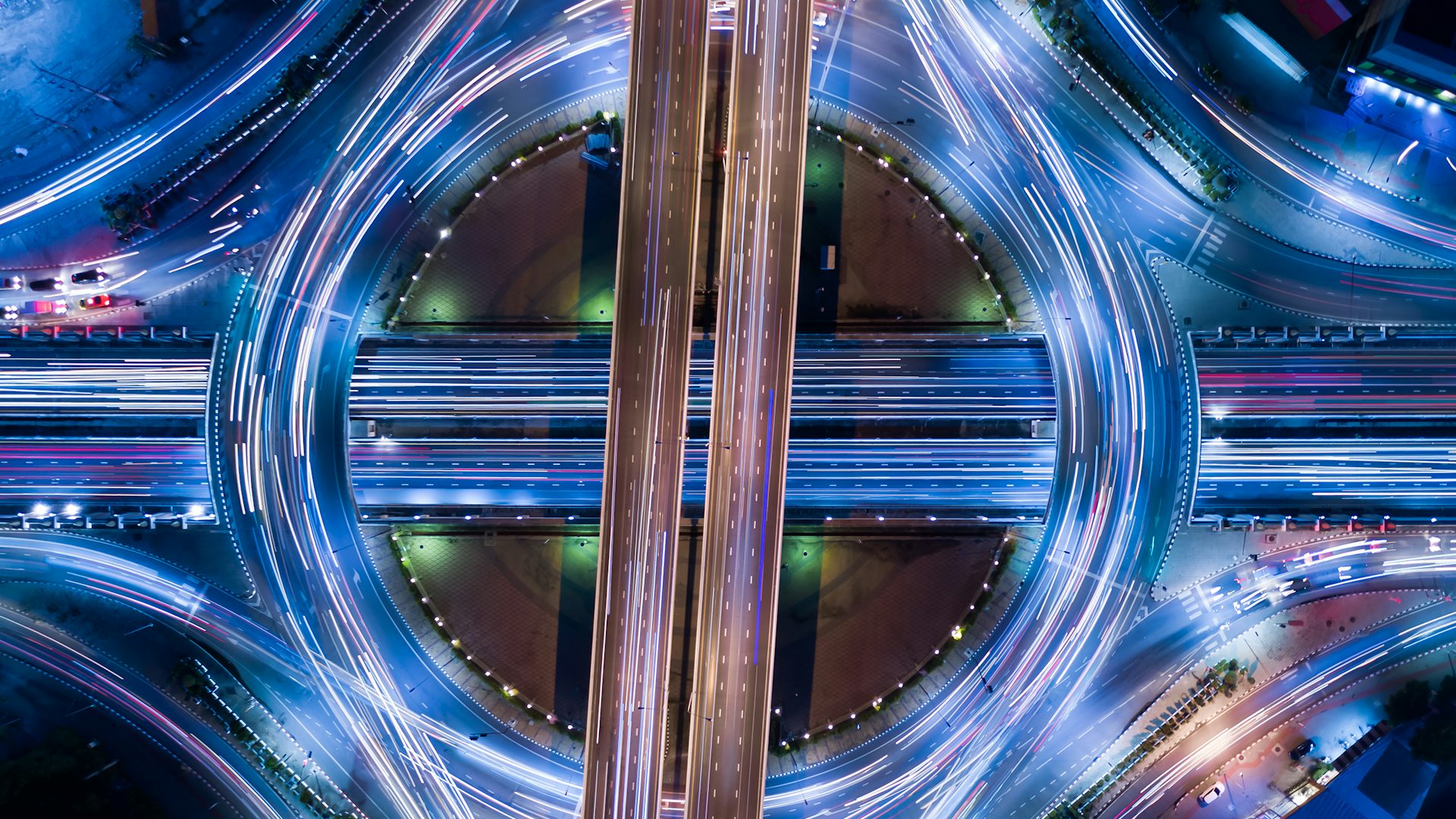 An overhead view of a traffic interchange at night.