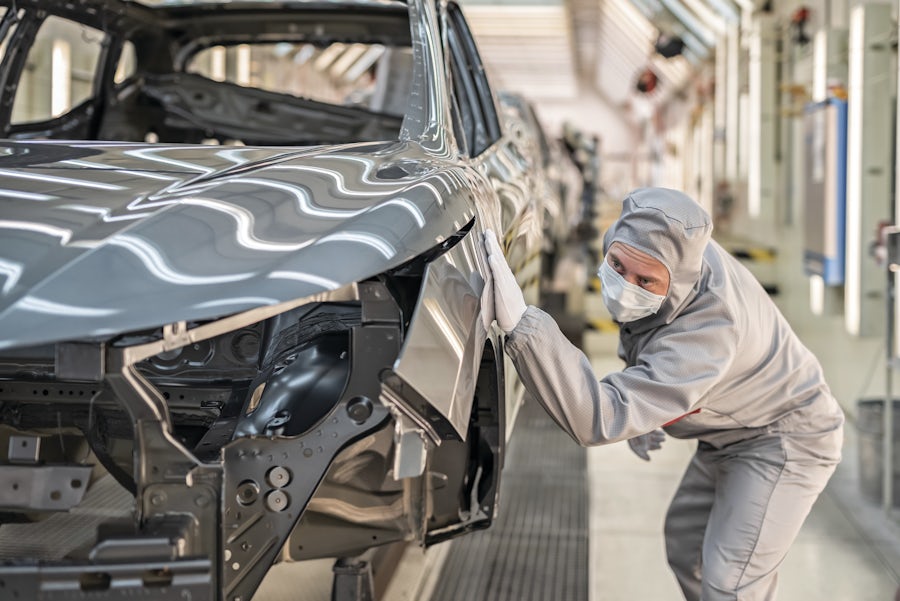 Engineer assembling an electric car design on the production line