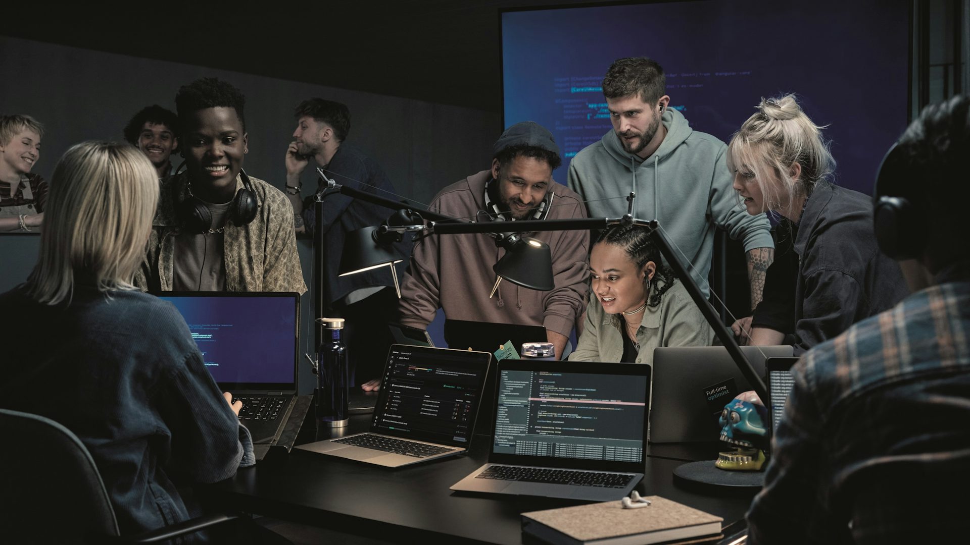 A group of engineers gathered around a laptop