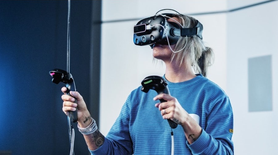 A woman wearing a VR headset, interacting with a virtual environment in smart manufacturing in the food and beverage industry setting