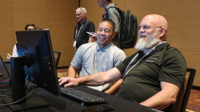 Two people at a hands-on training working on a computer at the technical conference, Realize LIVE