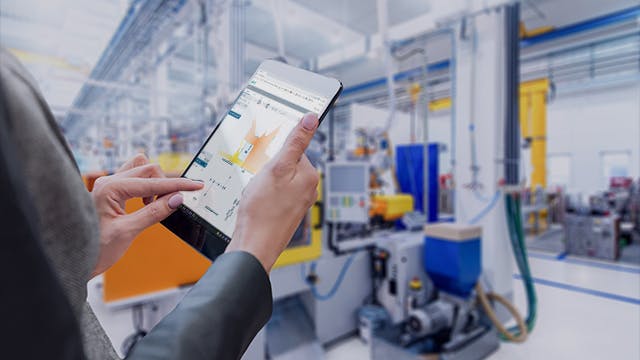 Business woman's hands working with a digital tablet in a large factory.