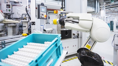 Ein Roboterarm verrichtet seine Arbeit in einer intelligenten Fertigungsanlage.