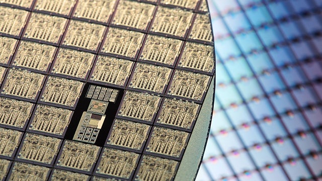 Picture of a silicon wafer (gold in color) with one chip not quite like the other