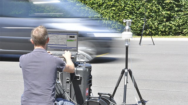 Inżynier ustawiający urządzenia na drodze, aby przeprowadzić testy hałasu przejazdu.