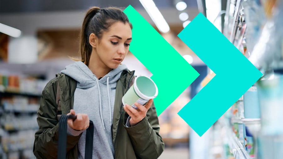 Eine Kundin in einem Lebensmittelgeschäft, die eine Produktverpackung liest. Dies veranschaulicht die Entscheidungsfindung der Verbraucher, die durch das Produktlebenszyklusmanagement in der Lebensmittel- und Getränkeindustrie beeinflusst wird.