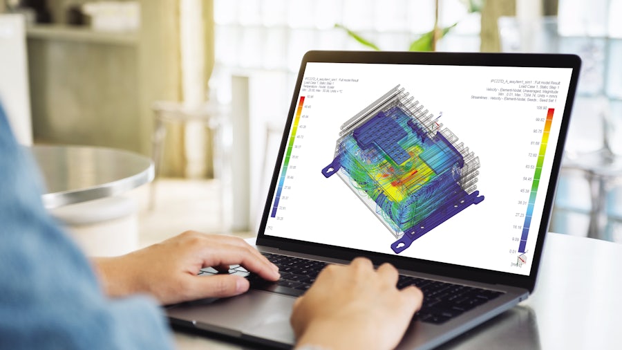 Engineer working on a computer performing a coupled thermo-fluid multiphysics simulation of an electronic box.