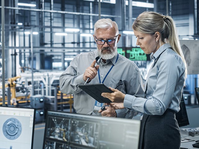 Ingenieros de control de calidad diagnosticando un problema potencial en el proceso de fabricación