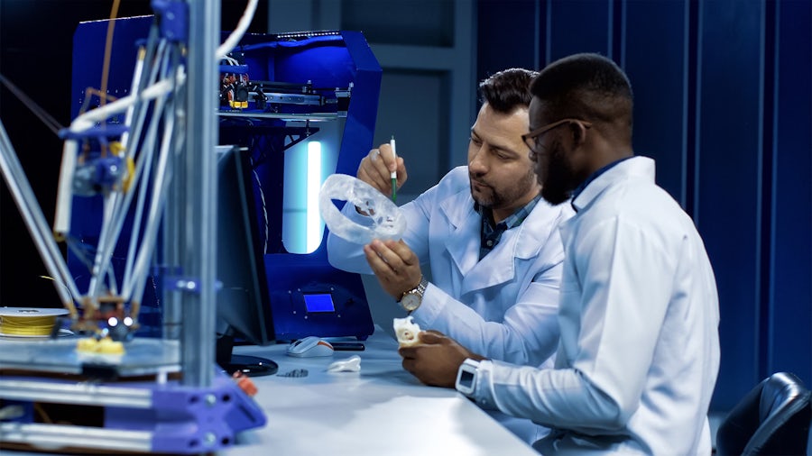 Two engineers conducting medical device design control while sitting in front of a computer.