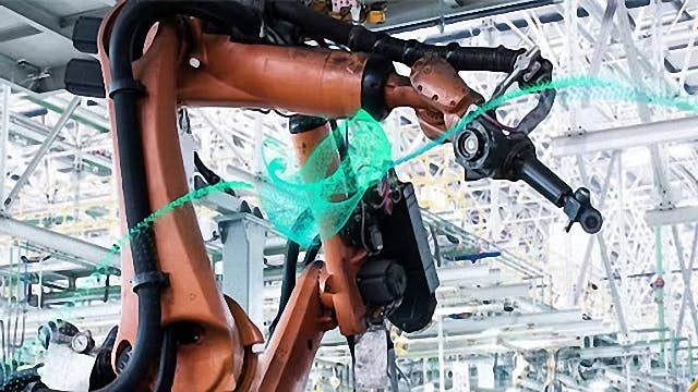 Un brazo robótico realiza trabajos en una fábrica industrial.