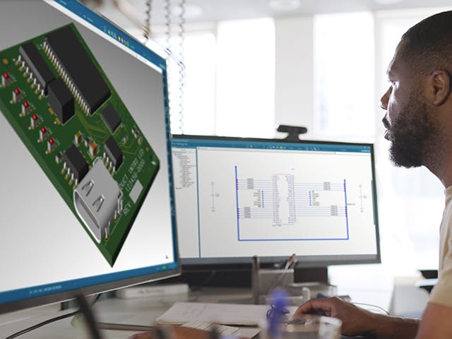 An engineer in front of dual monitors working on PCB design using PADS Pro Essentials.