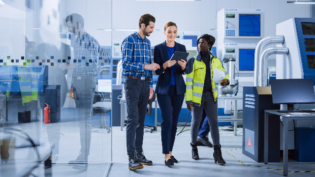 Three people on a factory floor