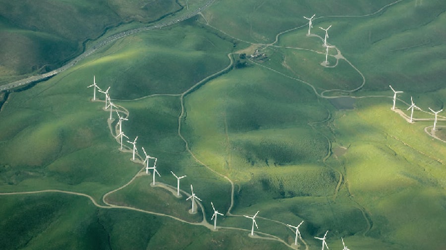 Wind turbines in a green field to produce sustainable energy