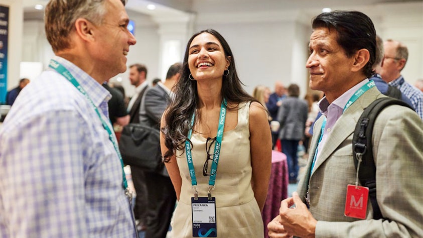 Three people standing in a circle at an industry reception at the Realize LIVE digital transformation conference.