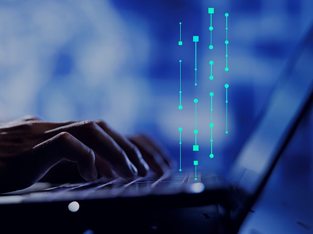 Hands typing on a laptop with Siemens data and technology lines emerging from the keyboard.