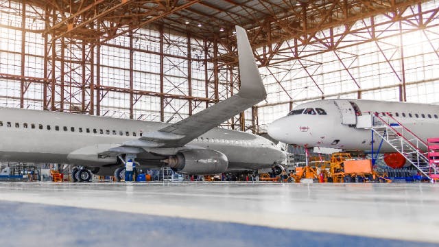 Two commercial aircraft in a hangar.