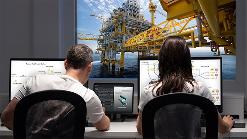 A man and a woman are looking at multiple screens.