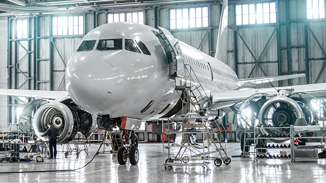 メンテナンスのためにエンジンが開放された格納庫内のジェット旅客機。