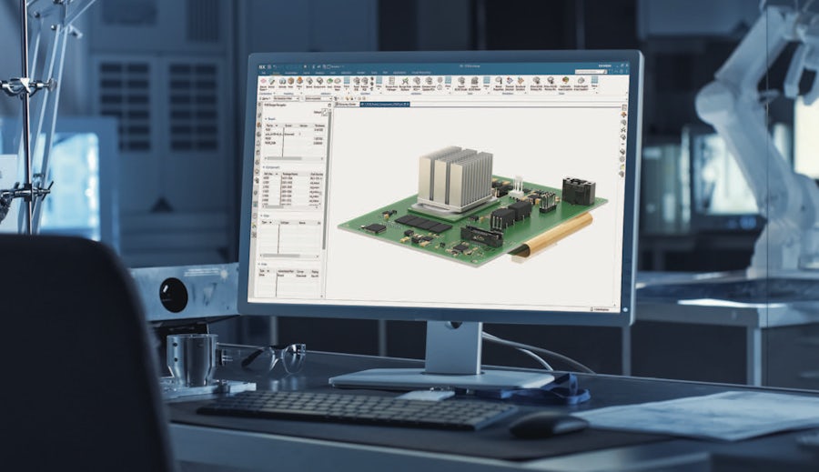A computer-aided design of an electronic circuit board on a computer monitor in a technical workspace. The complex PCB layout visible on the screen is an electronics design where electronic design automation software is used to develop a circuit board.