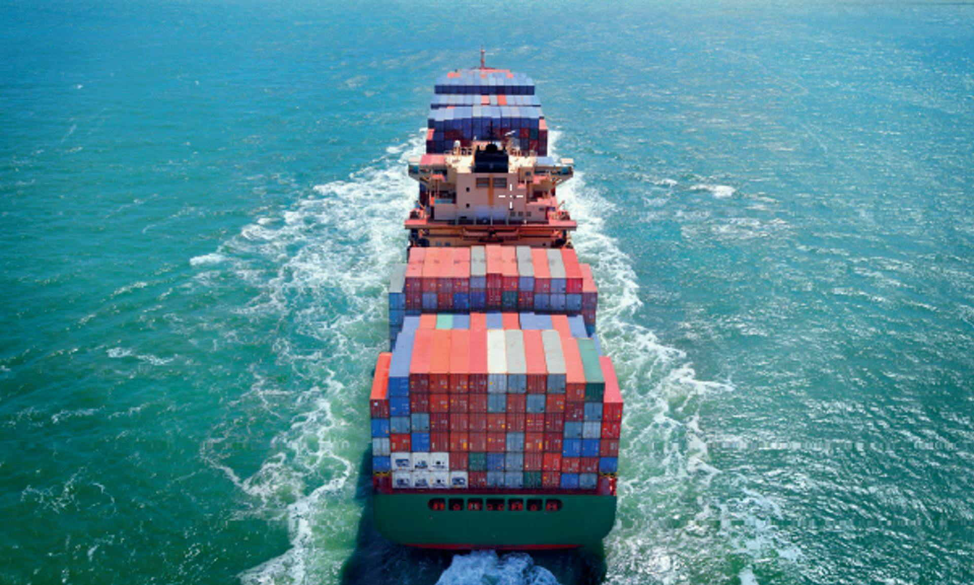 Large commercial container ship moving through the ocean.