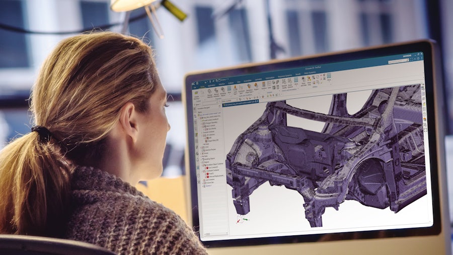 Engineer at computer screen making a large finite element mesh model for an automotive body.