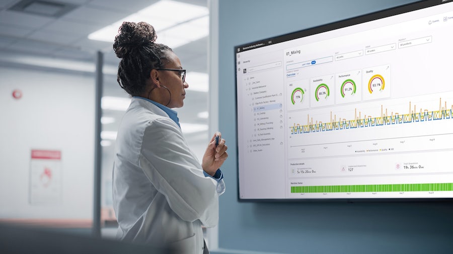 Woman looking at data on a large computer monitor.