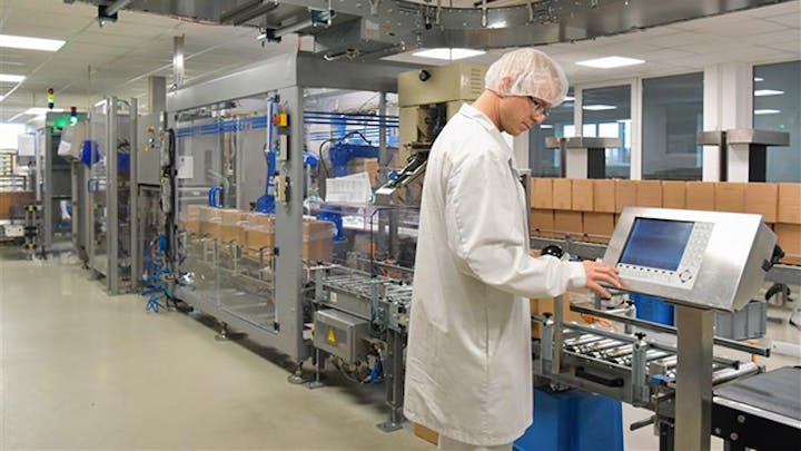 Image of a man in a white lab coat working with equipment in a laboratory or factory setting. The image is meant to convey the concept of supplier quality control.