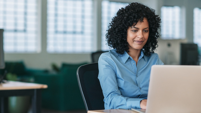 Woman working in an office on a computer.