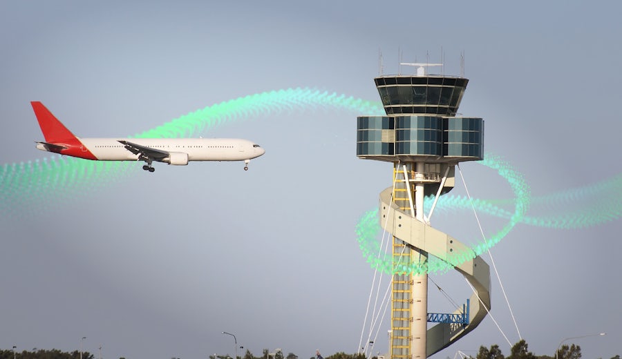 Airplane by tower at airport